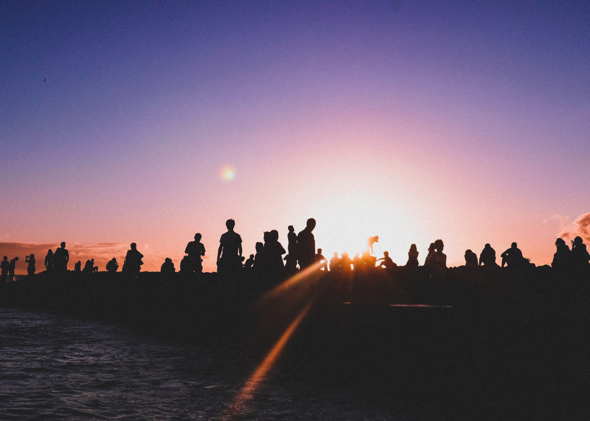 people standing together at sunset